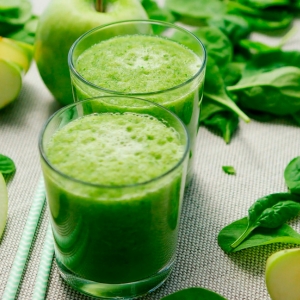Zwei Gläser grüner Detox-Smoothie mit Apfel und Spinat – gesundes Getränk zur Unterstützung von Entgiftung und Wohlbefinden.