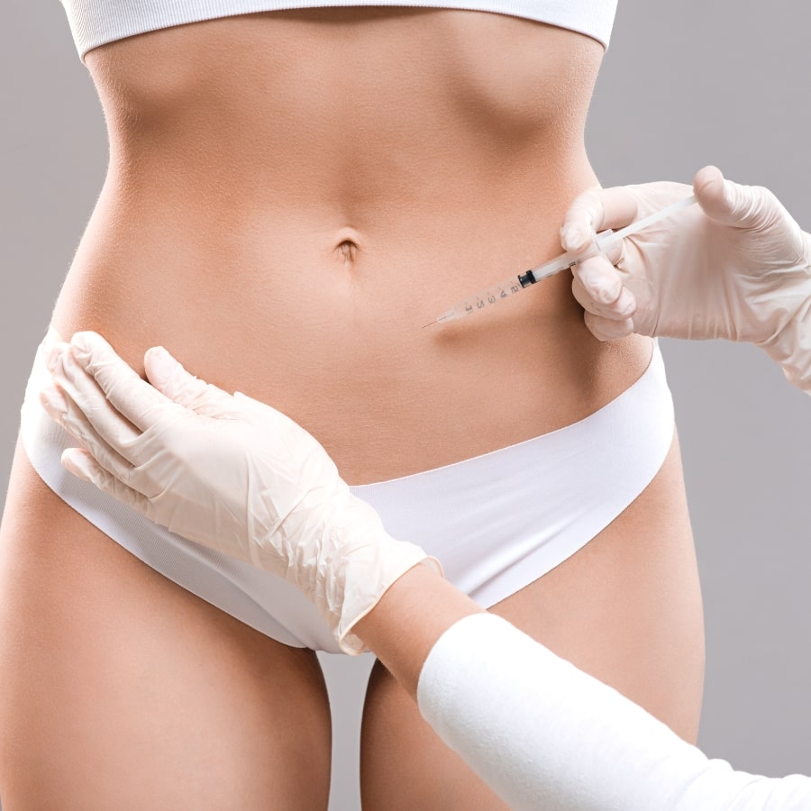 Injektion in den Bauchbereich einer Patientin durch medizinisches Fachpersonal – Anwendung der Fett-weg-Spritze zur lokalen Fettreduktion.