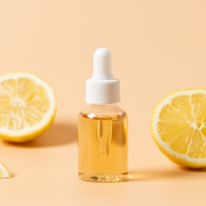 Glasfläschchen mit Pipette, gefüllt mit Vitamin-C-Serum, umgeben von frischen Zitronenscheiben – Symbol für Hautpflege und natürliche Antioxidantien.